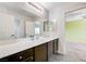 Bright bathroom features a large mirror, extended vanity, and tile floors at 6656 Fort William St, North Las Vegas, NV 89084