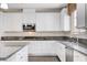 Kitchen featuring white cabinets, stainless steel appliances, and granite countertops at 6656 Fort William St, North Las Vegas, NV 89084