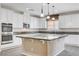 Bright kitchen featuring white cabinets, granite countertops, a central island, and stainless steel appliances at 6656 Fort William St, North Las Vegas, NV 89084
