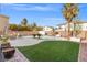 Large backyard features a pool, spa, patio, and artificial turf at 7078 Seabirds Pl, North Las Vegas, NV 89084