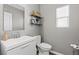 Clean and simple bathroom features a white vanity, toilet, decorative mirror and modern fixtures at 7078 Seabirds Pl, North Las Vegas, NV 89084