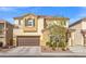 Inviting two-story home with a brown garage door, desert landscaping, and a charming entryway at 7078 Seabirds Pl, North Las Vegas, NV 89084