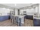 Kitchen with white upper cabinets, blue lower cabinets, granite countertops and a large kitchen island at 7078 Seabirds Pl, North Las Vegas, NV 89084