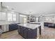Open concept kitchen with island seating and stainless steel appliances, offering views to the living room at 7078 Seabirds Pl, North Las Vegas, NV 89084