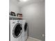 Practical laundry room features washer and dryer with shelving at 7078 Seabirds Pl, North Las Vegas, NV 89084