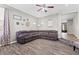 Spacious living room featuring a large brown sectional, wood-look tile floors, and neutral paint at 7078 Seabirds Pl, North Las Vegas, NV 89084