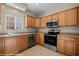 Well-lit kitchen features stainless steel appliances, light wood cabinetry, and a stainless sink under a window at 730 Hardy Way # A, Mesquite, NV 89027