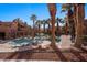 A community pool surrounded by palm trees is enclosed with a fence at 730 Hardy Way # A, Mesquite, NV 89027