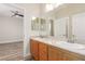 Bathroom featuring double sinks with light wood vanity and ample mirror space and views at 7338 Flying Pegasus Ct, Las Vegas, NV 89131