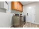 Laundry room showcasing modern washer and dryer, storage cabinets, and convenient access to the exterior at 7338 Flying Pegasus Ct, Las Vegas, NV 89131