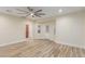 Bright living room with neutral walls, ceiling fan, stylish wood-look floors, and access to the backyard at 7338 Flying Pegasus Ct, Las Vegas, NV 89131