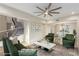 Bright living room featuring modern furniture, a decorative stairway, and a large ceiling fan at 7338 Flying Pegasus Ct, Las Vegas, NV 89131