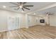 Spacious living room with a fireplace, ceiling fans, shutters, and porcelain wood-look tile floors at 7338 Flying Pegasus Ct, Las Vegas, NV 89131