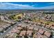 This aerial shot features a well-planned community with a golf course and uniform housing designs under a blue sky at 7564 Wingspread St, North Las Vegas, NV 89084