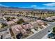 An aerial view showcases a neighborhood with tidy landscaping and well-maintained homes under a clear blue sky at 7564 Wingspread St, North Las Vegas, NV 89084