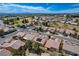 An aerial image presents a community nestled among green spaces, with views of the city and distant mountains at 7564 Wingspread St, North Las Vegas, NV 89084