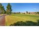View of a community golf course and sidewalks lined with trees and houses at 7564 Wingspread St, North Las Vegas, NV 89084