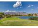 Lush green golf course overlooking a tranquil lake and distant mountains, showcasing a beautiful outdoor setting at 7564 Wingspread St, North Las Vegas, NV 89084