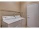 Laundry room features appliances, wire shelving, and access to an exterior door at 7564 Wingspread St, North Las Vegas, NV 89084