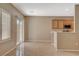 Neutral living space leads to the back patio and features view into the kitchen at 7564 Wingspread St, North Las Vegas, NV 89084