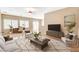 Staged living room featuring neutral decor, ceiling fan, and tile flooring at 7564 Wingspread St, North Las Vegas, NV 89084