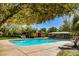 Sparkling community pool area featuring lounge chairs, a covered pavilion, and beautiful landscaping at 7649 Calico Fields St, Las Vegas, NV 89149