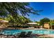 Beautiful community pool with lounge chairs and shade canopies for a relaxing experience at 7649 Calico Fields St, Las Vegas, NV 89149