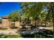 Community entrance with a stone sign, lush landscaping, and a view of the pool area at 7649 Calico Fields St, Las Vegas, NV 89149