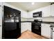 Kitchen showcasing black appliances, white cabinets, and modern tile flooring at 7649 Calico Fields St, Las Vegas, NV 89149