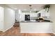 Well-lit kitchen with white cabinets and black appliances, conveniently located next to the open living area at 7649 Calico Fields St, Las Vegas, NV 89149