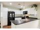 Well-lit kitchen with white cabinets, black appliances, and a stainless-steel sink at 7649 Calico Fields St, Las Vegas, NV 89149