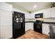 Kitchen featuring white cabinets, black appliances, and tile flooring at 7649 Calico Fields St, Las Vegas, NV 89149