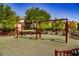 Outdoor playground area featuring swings, benches, and mature landscaping for Gathering enjoyment at 7649 Calico Fields St, Las Vegas, NV 89149