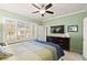 Well-lit bedroom with ceiling fan, large window, and dark wood dresser at 7904 Fantail Dr, North Las Vegas, NV 89084