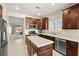 Open concept kitchen featuring stainless appliances, dark cabinetry, kitchen island and views to the living area at 7904 Fantail Dr, North Las Vegas, NV 89084
