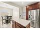 A kitchen featuring an island with a white countertop, dark wood cabinets, and stainless steel appliances at 7904 Fantail Dr, North Las Vegas, NV 89084