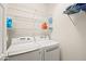 Close up of the white washer and dryer with shelving in the laundry room at 7904 Fantail Dr, North Las Vegas, NV 89084