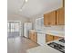 Kitchen with light wood cabinets, white appliances, and sliding glass door at 8472 W Gilmore Ave, Las Vegas, NV 89129