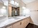 Bathroom featuring double sinks, white cabinets, stone countertops, and a glass-enclosed shower at 8705 Red Brook Dr # 203, Las Vegas, NV 89128