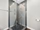 Modern walk-in shower showcasing glass doors, grey tiles, and pebble flooring at 8705 Red Brook Dr # 203, Las Vegas, NV 89128
