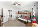 Bedroom with a bunk bed, neutral carpeting, and an open doorway to adjacent rooms at 9120 Mastodon Ave, Las Vegas, NV 89149