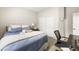 Cozy bedroom featuring a comfortable bed, a desk, and a closet with mirrored sliding doors at 9120 Mastodon Ave, Las Vegas, NV 89149