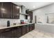 Stylish kitchen with subway tile backsplash, dark cabinets, and a stainless steel range hood at 9120 Mastodon Ave, Las Vegas, NV 89149