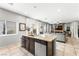 Open kitchen featuring an island, tile floors, and stainless steel appliances, seamlessly flowing into the living area at 9120 Mastodon Ave, Las Vegas, NV 89149