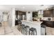 Modern kitchen showcasing dark wood cabinets, stainless steel appliances, an island, and four barstools at 9120 Mastodon Ave, Las Vegas, NV 89149