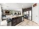 Modern kitchen featuring stainless steel appliances, tile flooring, dark wood cabinets, and a breakfast bar at 9120 Mastodon Ave, Las Vegas, NV 89149