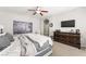 This main bedroom features neutral paint, a ceiling fan, carpet, and a dresser with TV at 9120 Mastodon Ave, Las Vegas, NV 89149