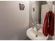 A simple bathroom features a floating sink and round mirror, creating a minimalist design at 9160 Lynea Ct, Las Vegas, NV 89178