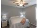 A simply decorated bedroom with a white comforter, ceiling fan and neutral walls at 9160 Lynea Ct, Las Vegas, NV 89178
