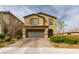 Inviting two-story home with a brick driveway, lush landscaping, and a charming facade, with a two car garage at 9160 Lynea Ct, Las Vegas, NV 89178